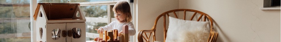 Enfant joue seul dans sa chambre avec des jouets en bois
